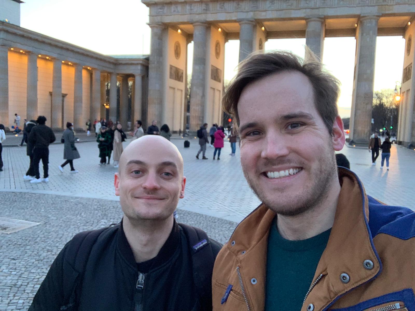 Two men in front of the Brandenburg Gate in Berlin