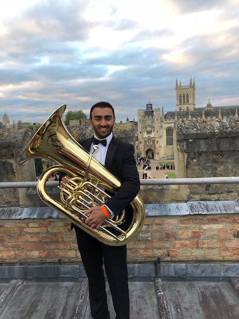 Young man in smart clothes holding a tuba