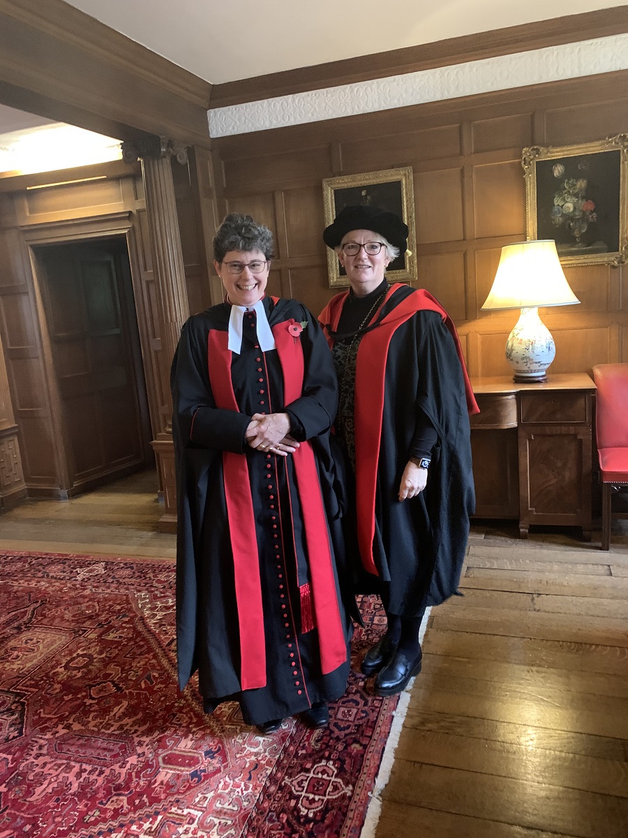 Two woman in academic dress of red and scarlet